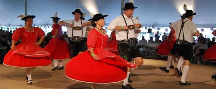 Schuhplattler dancers in traditional dress spinning on a dance floor